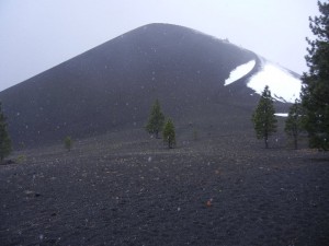 Cinder Cone (the trail to the summit is visible curving up across the snow field)