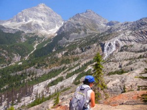 Amy hiking amid views of mountain peaks, glaciers, and waterfalls